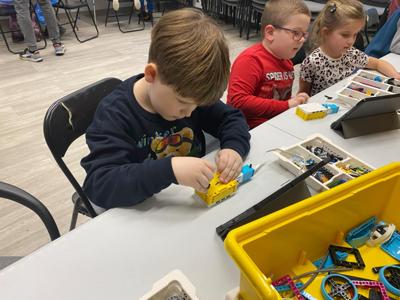 Zdjęcie przestawia uczestników zajęć Zabawa i Programowanie. Zdjęcie wykonano w Bibliotece.