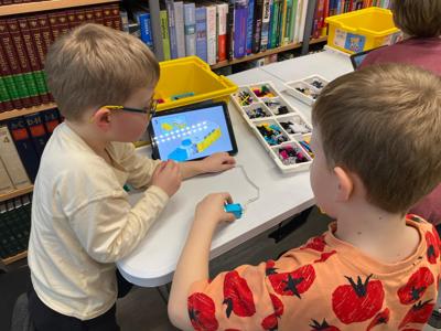 Zdjęcie przestawia uczestników zajęć Zabawa i Programowanie. Zdjęcie wykonano w Bibliotece.