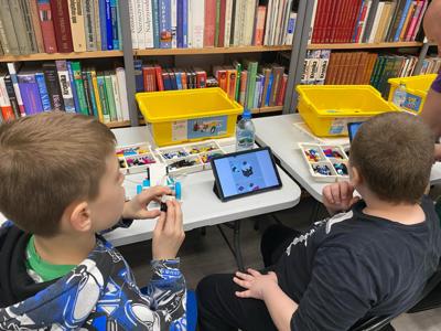 Zdjęcie przestawia uczestników zajęć Zabawa i Programowanie. Zdjęcie wykonano w Bibliotece.
