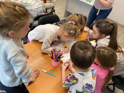 Zdjęcie przedstawia uczestników zajęć o emocjach. Zdjęcie wykonano w Bibliotece.