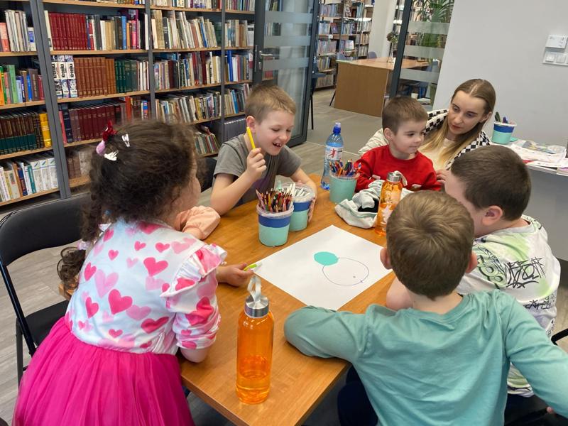 Zdjęcie przedstawia uczestników zajęć o emocjach. Zdjęcie wykonano w Bibliotece.