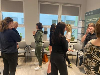 Zdjęcie przedstawia uczestniczki warsztatów  samoobrony. Zdjęcie wykonano w Bibliotece.
