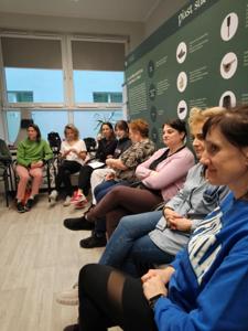 Zdjęcie przedstawia uczestniczki warsztatów  samoobrony. Zdjęcie wykonano w Bibliotece.