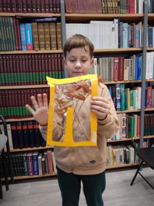 Na zdjęciu znajduje się uczestnik zajęć o tematyce jesiennej. Zdjęcie wykonano w bibliotece.