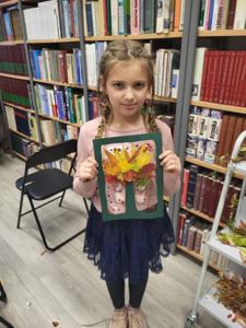 Na zdjęciu znajduje się uczestnik zajęć o tematyce jesiennej. Zdjęcie wykonano w bibliotece.