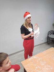 Na zdjęciu znajdują się dzieci siedzące przy stołach. Zdjęcie wykonano w bibliotece.