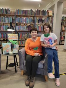 Na zdjęciu znajdują się uczestnicy zajęć. W tle książki.