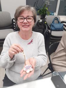 Na zdjęciu znajdują się Panie trzymające drewniane przedmioty. Zdjęcie wykonano w bibliotece.