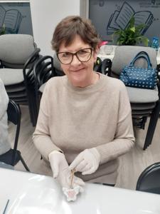 Na zdjęciu znajdują się Panie trzymające drewniane przedmioty. Zdjęcie wykonano w bibliotece.