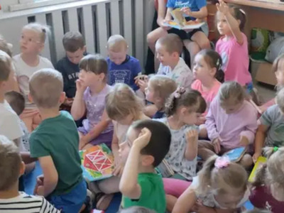 Zdjęcia przedstawia dzieci z przedszkola w Dębnicy podczas lekcji bibliotecznej