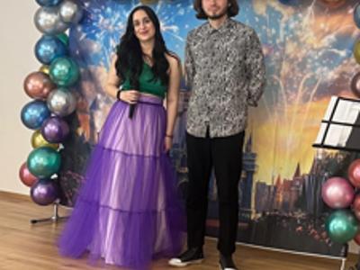 Zdjęcie przedstawia wokalistów na scenie na bajkowym tle