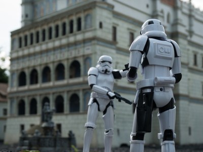 Figurki ze znanej sagi Star Wars przed miniaturą poznańskiego Ratusza.
