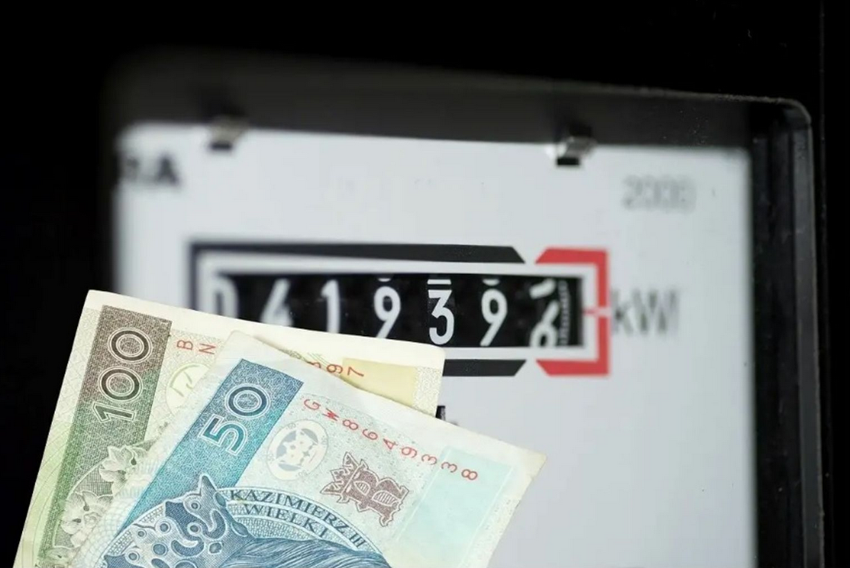 Na zdjęciu licznik energii oraz pieniądze 50 i 100 złotych.