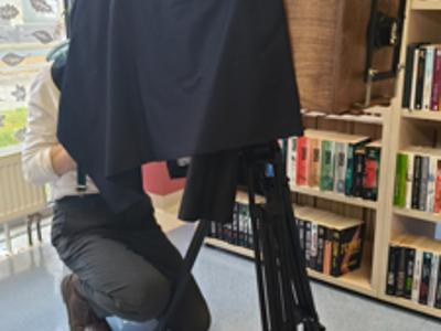 Fotograf ukryty pod płachtą za aparatem