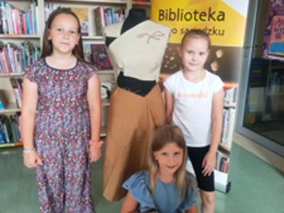 Trzy dziewczynki pozują przy swoim projekcie