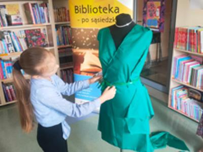 Dziewczynka poprawia zieloną sukienkę
