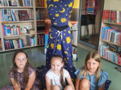 Trzy dziewczynki pozują przy swoim projekcie