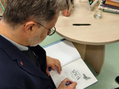 Michał Rusinek podpisujący książkę.