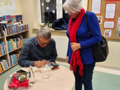 Marcin Meller podpisujący książkę kobiecie.