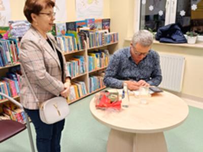 Marcin Meller podpisujący książkę kobiecie.