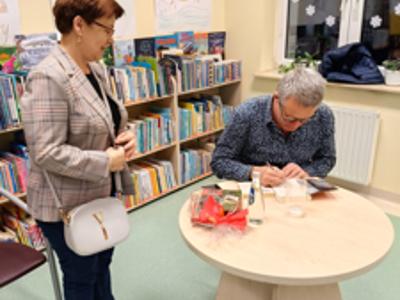 Marcin Meller podpisujący książkę kobiecie.