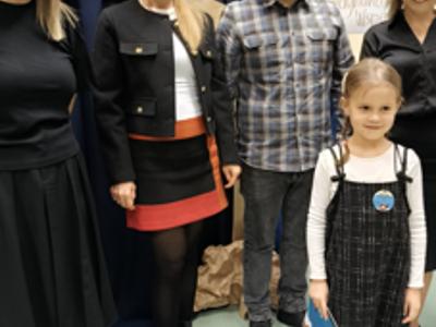 Zespół wręczający nagrody z dziewczynką