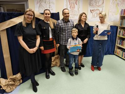 Zespół wręczający nagrody z chłopcem