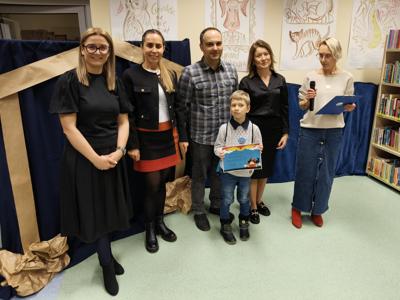 Zespół wręczający nagrody z chłopcem