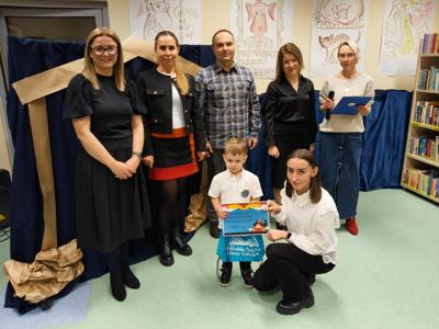 Zespół wręczający nagrody z chłopcem