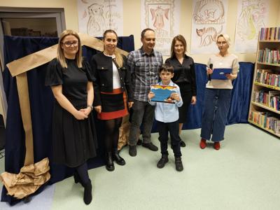 Zespół wręczający nagrody z chłopcem