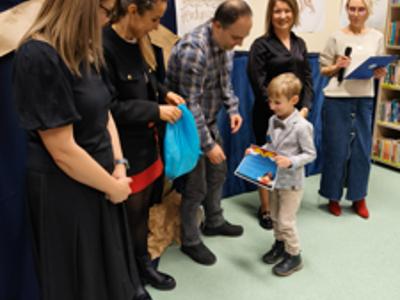 Zespół wręczający nagrody z chłopcem