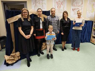 Zespół wręczający nagrody z chłopcem