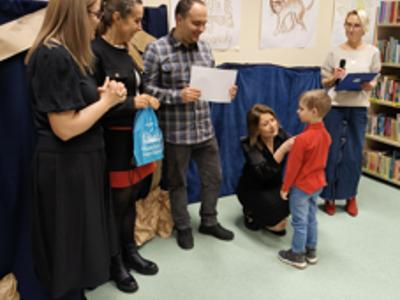 Zespół wręczający nagrody z chłopcem