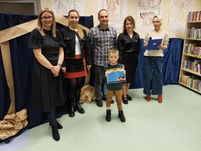 Zespół wręczający nagrody z chłopcem