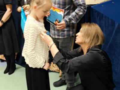 Zespół wręczający nagrody z dziewczynką