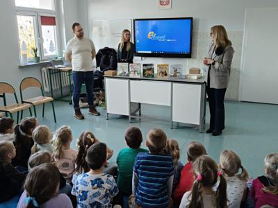 Grupa dzieci siedząca przed prowadzącymi