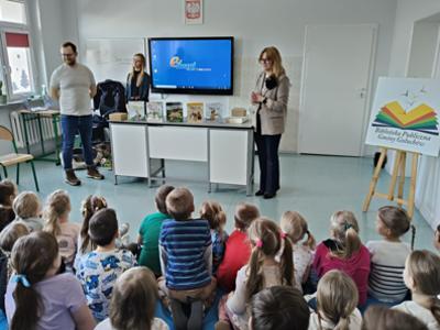 Grupa dzieci siedząca przed prowadzącymi