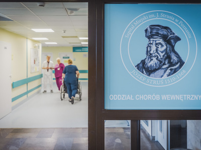 Wejście na Oddział. Na pierwszym planie logo Szpitala z nazwą Oddziału. W głębi kierownik Oddziału i pielęgniarka oddziałowa.