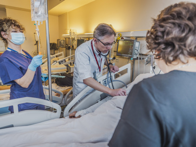 Kierownik Oddziału z lekarką i pielęgniarką przy łóżku pacjenta