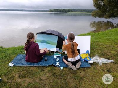 Dziewczynki malują nad jeziorem