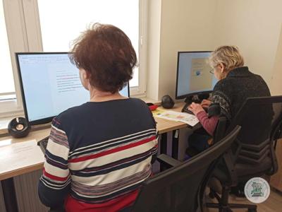 Seniorzy podczas zajęć komputerowych w pracowni.