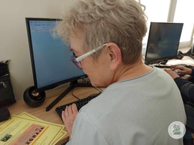 Seniorzy podczas zajęć komputerowych w pracowni.