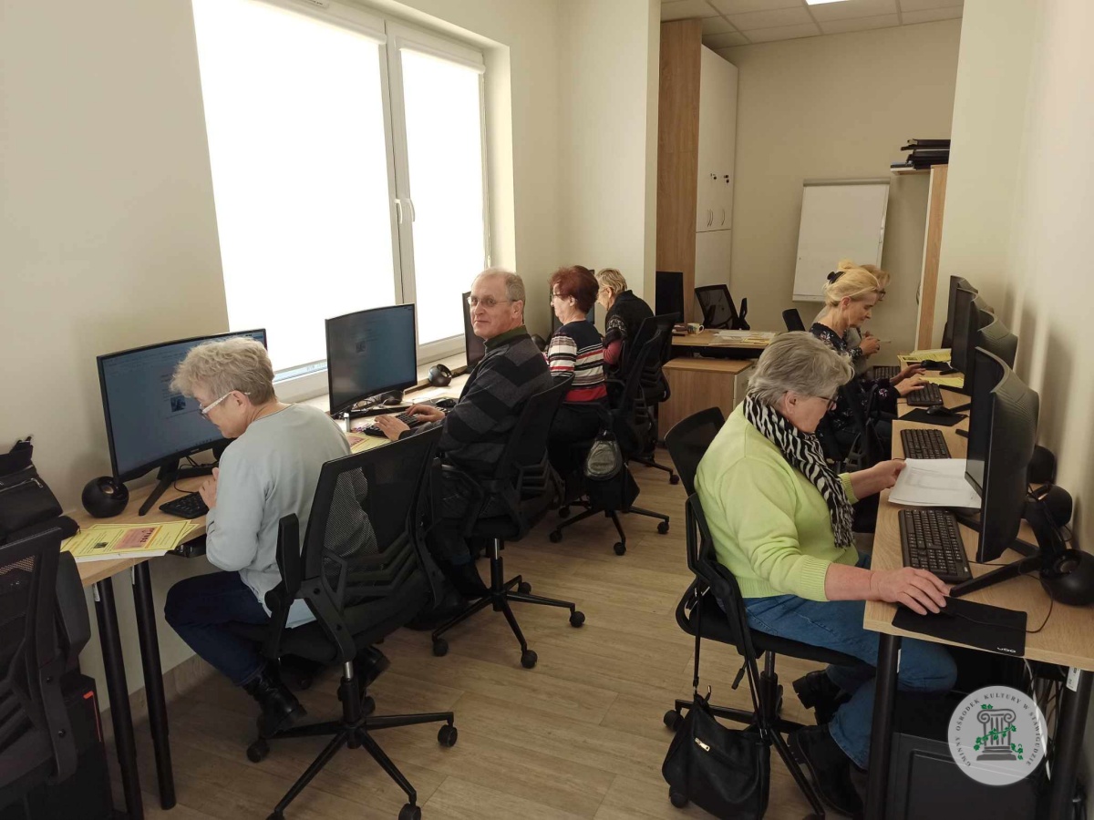 Seniorzy podczas zajęć komputerowych w pracowni.