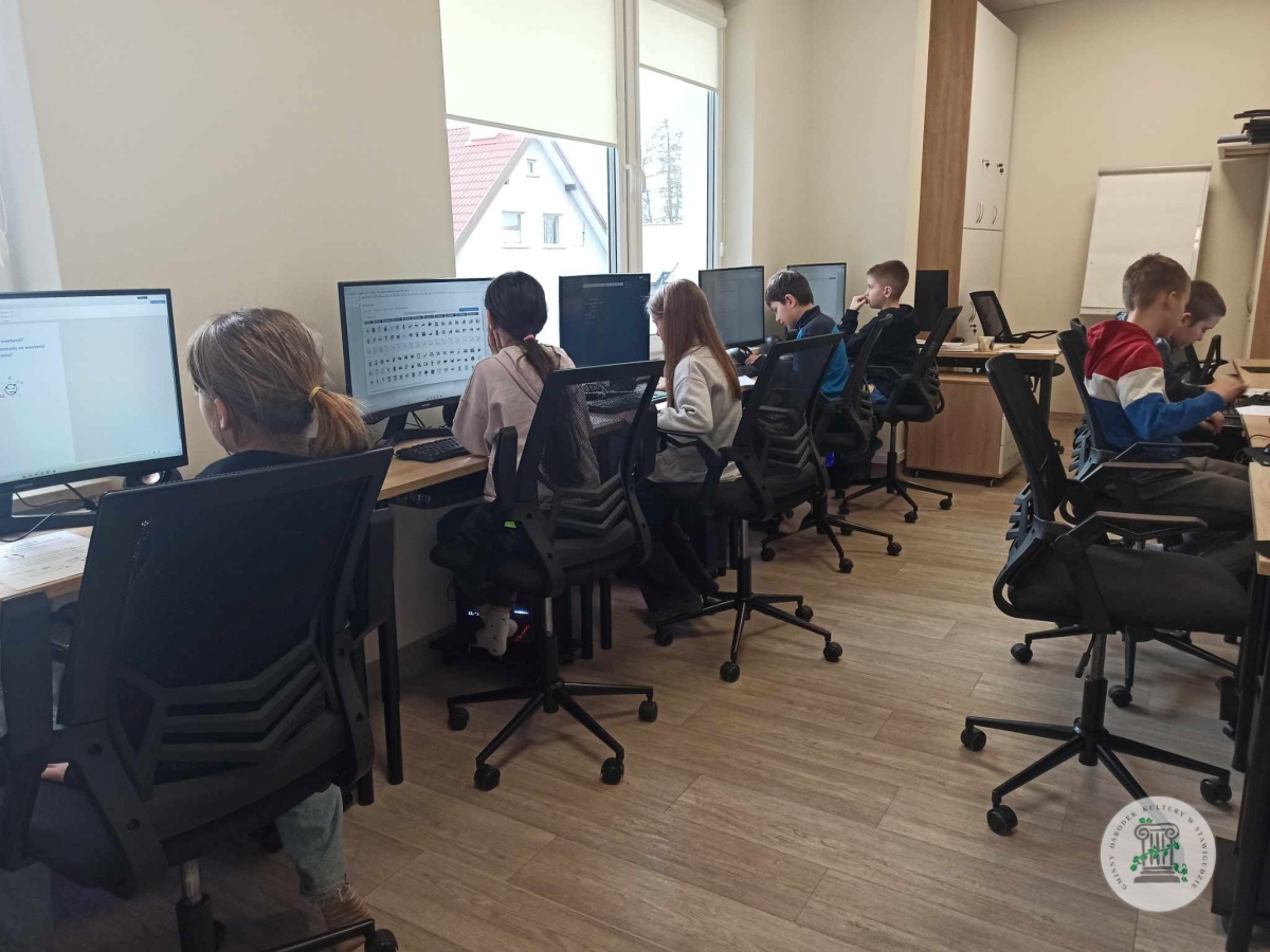dzieci podczas zajęć z projektowania graficznego w pracowni informatycznej.