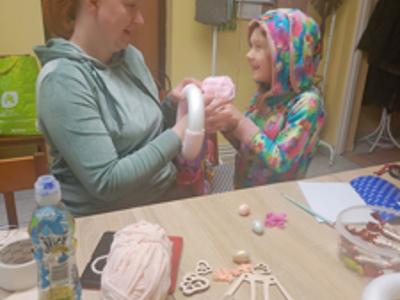 Mama z córką wykonują wieniec w Bartagu.