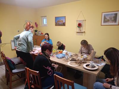 Uczestnicy dzieci i rodzice pracują w sali w Bartagu.