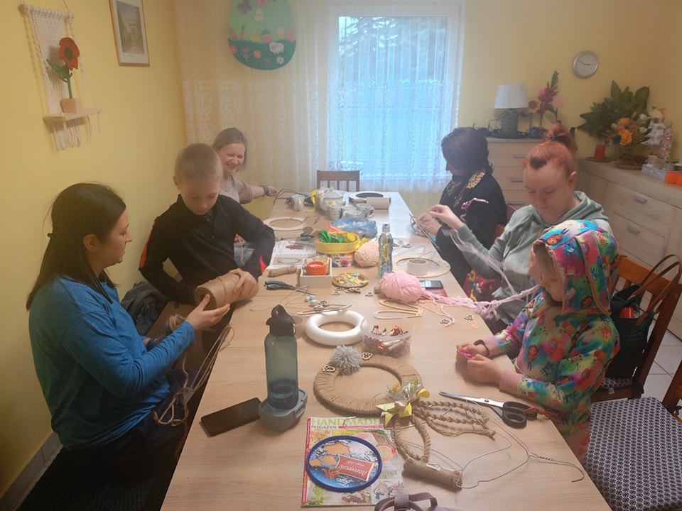 Uczestnicy zajęć w Bartagu przy stoliku pracy.