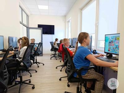 Grupa dzieci podczas zajęć z projektowania graficznego w Stawigudzie