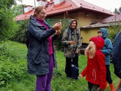 na zdjęciu Prowadząca opowiada o ziołach rosnących w Tomaszkowie