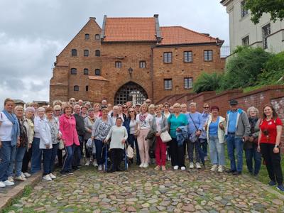 Grupa seniorów wraz z przewodniczką podczas wycieczki w Grudziądzu
